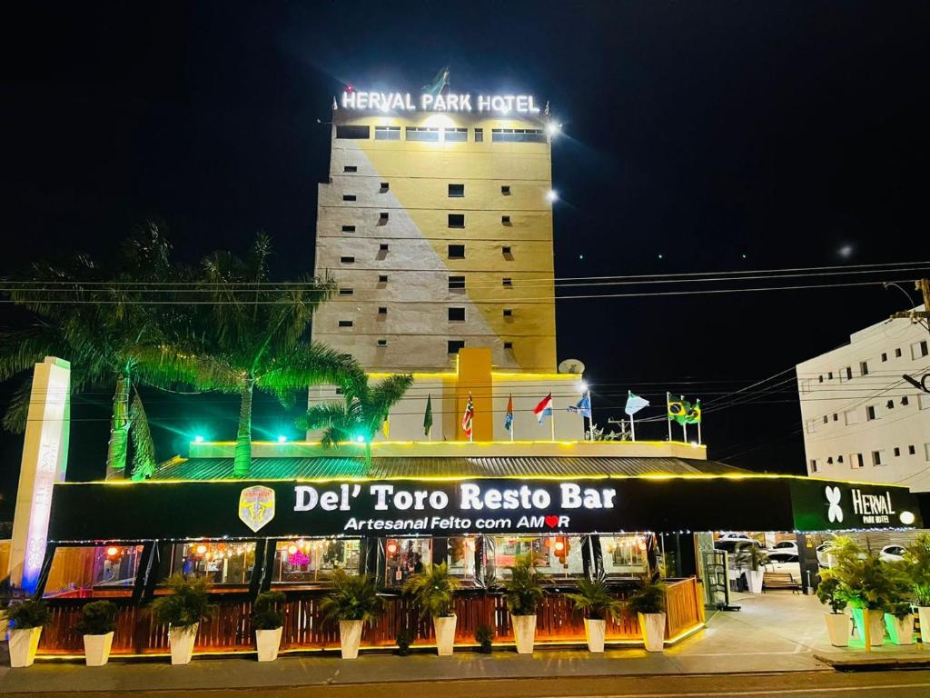 a building with a dj top ricoya bar at night at Herval Park Hotel in Ponta Porã