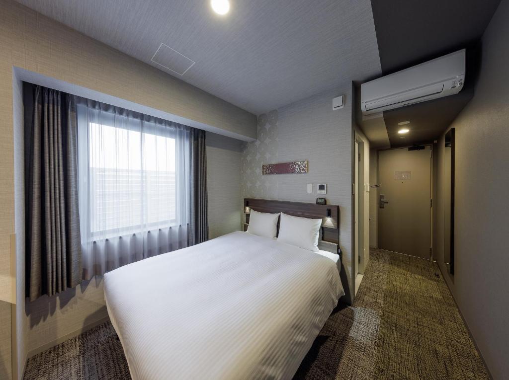 Postel nebo postele na pokoji v ubytování Smile Hotel Kanazawa Nishiguchi Ekimae