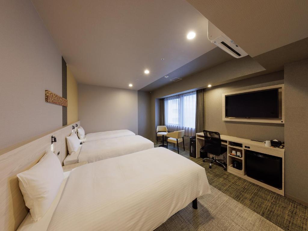 Postel nebo postele na pokoji v ubytování Smile Hotel Kanazawa Nishiguchi Ekimae