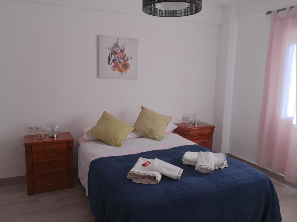 1 dormitorio con 1 cama con toallas en confortable y luminoso piso 5 camas, parking gratis en Málaga