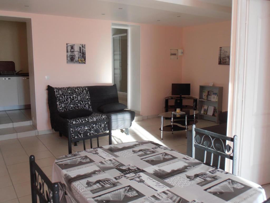 a living room with a table and a couch at La Rivière Meublé de Tourisme 2 étoiles in Laroche-Saint-Cydroine