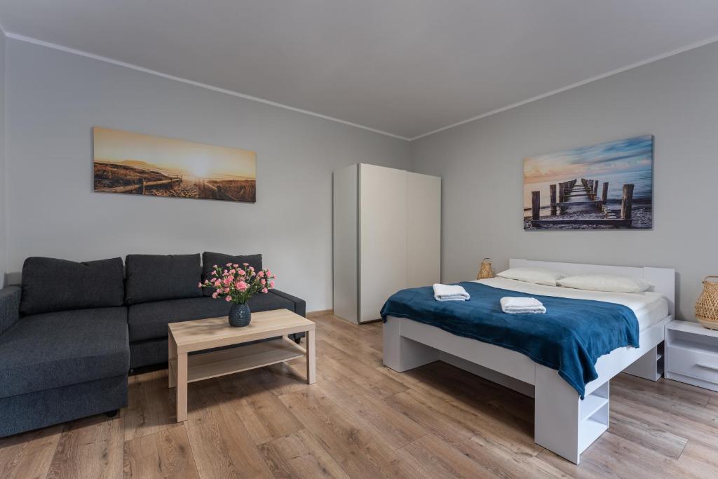- un salon avec un lit et un canapé dans l'établissement Sopot Host Garden, à Sopot