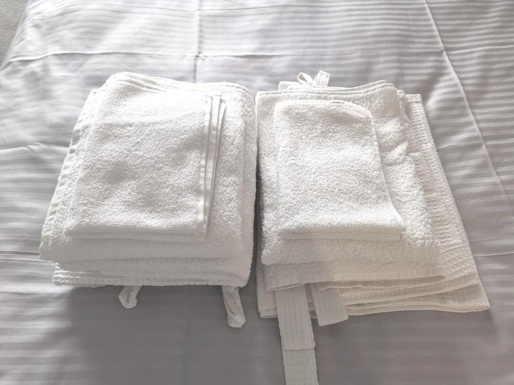 two towels sitting on top of a bed at Modern stylish apartments on Lazurna Street in the RC Riviera overlooking the river in Mykolaiv