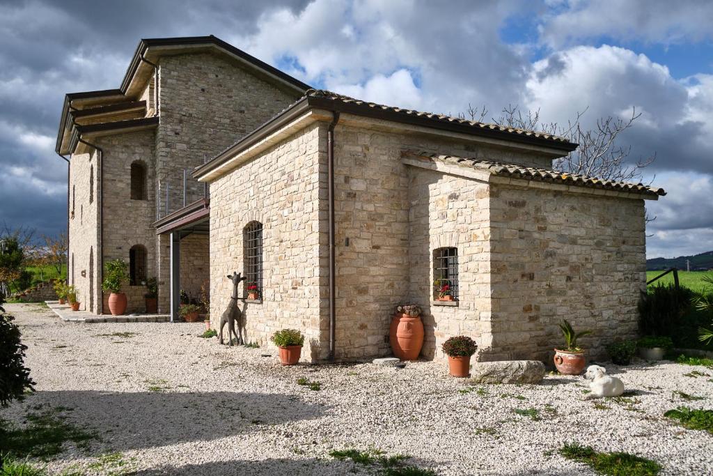 a stone building with a cat standing in front of it at Monolocale di Campagna - LePietreBnB in Pietrelcina