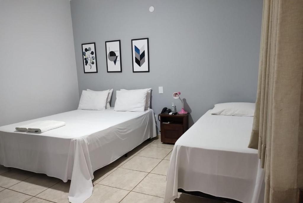 2 Betten nebeneinander in einem Zimmer in der Unterkunft Shellter Hotel in Holambra