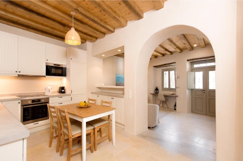 een keuken en eetkamer met een tafel en stoelen bij Ariadne's Kastro Boutique Apartment in Naxos Chora