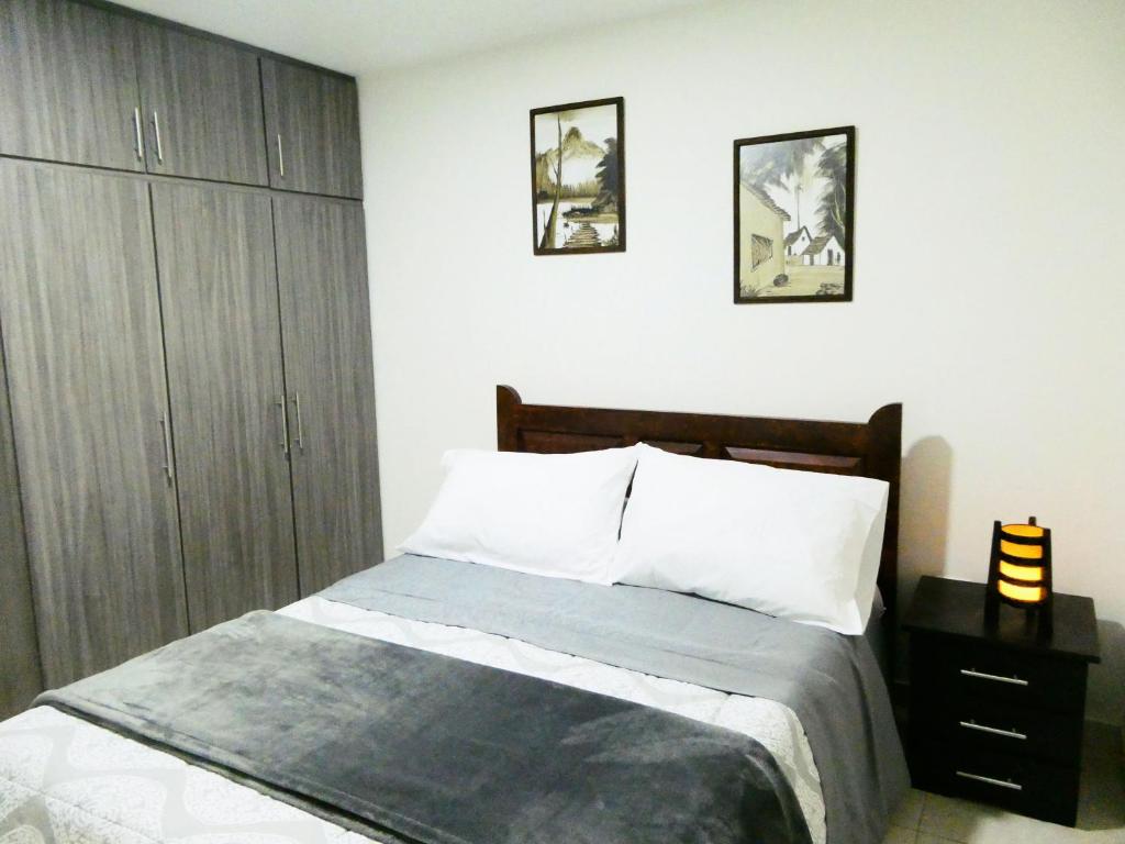 1 dormitorio con 1 cama y armario de madera en Apartamento Descanso Central, en Filandia