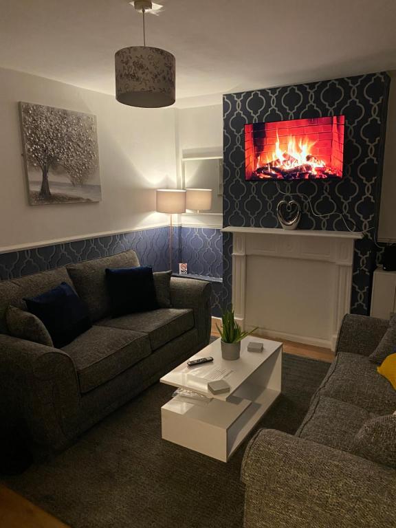 a living room with a couch and a fireplace at Cosy 3 Bedroom house, Free parking & WIFI in Nottingham