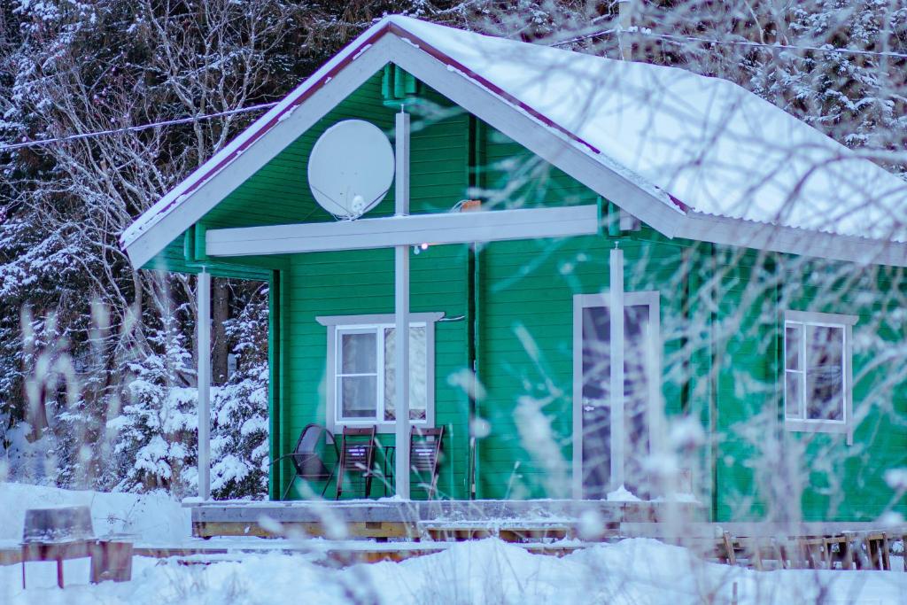 una casa verde en la nieve con nieve en Дом LBerry Мята у Ладоги en Sortavala