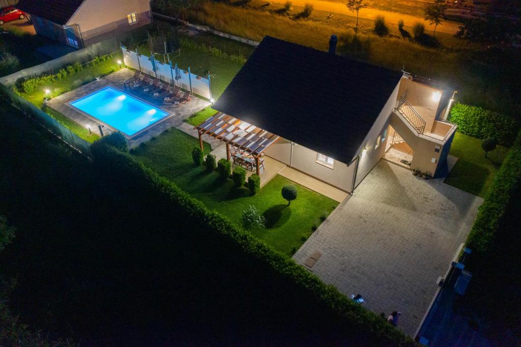 an overhead view of a house with a swimming pool at night at Villa Fila in Sinj