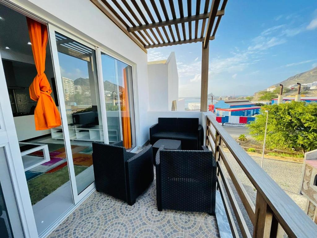 a balcony with a couch and chairs on a balcony at Duarte Apartments - Laginha in Mindelo