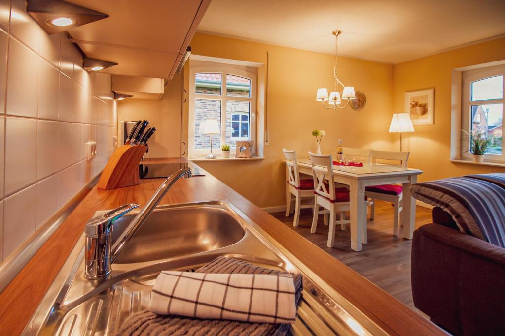 a kitchen with a sink and a dining room at Int Hörn 1 EG in Krummhörn