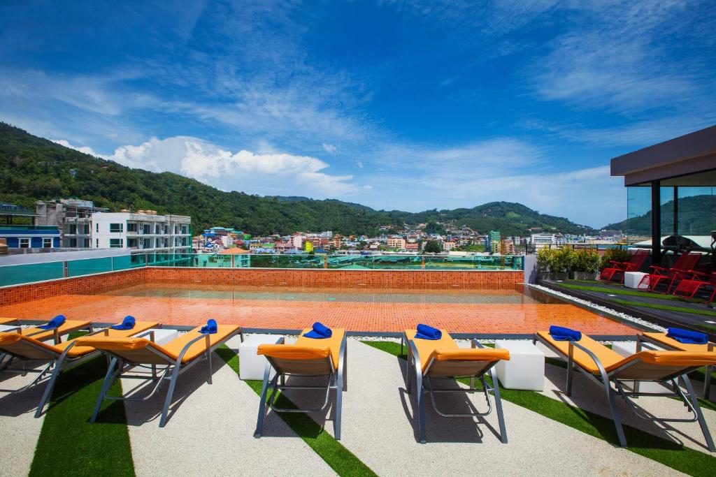 a balcony with chairs and a swimming pool at The Crib Patong - SHA Certified in Patong Beach