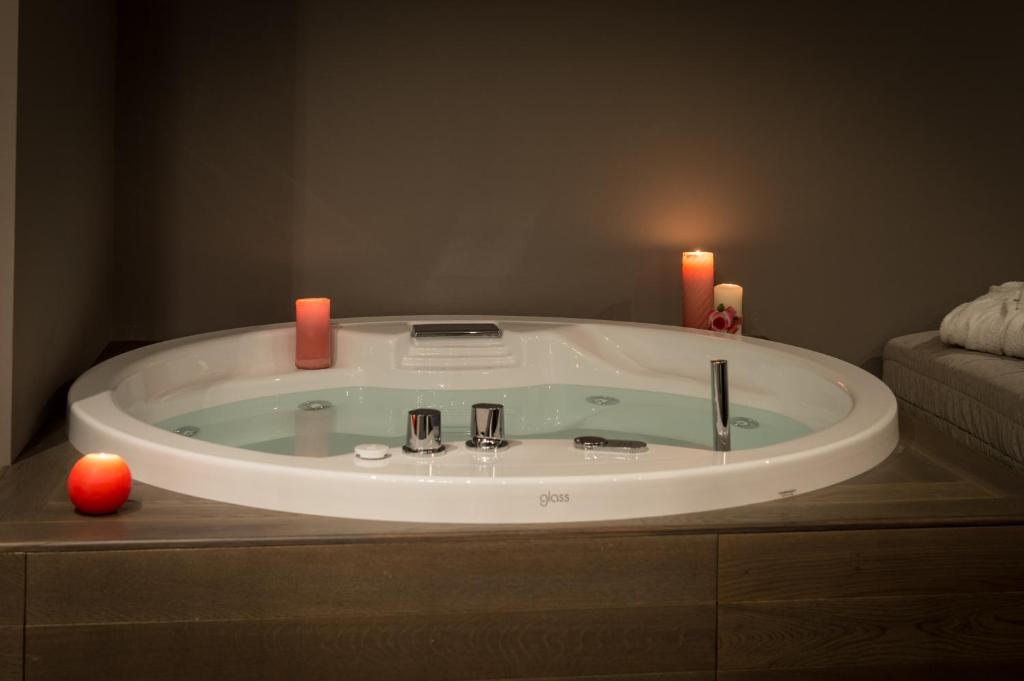 a bathroom with a bath tub with two candles at Hotel Belvedere in Milano Marittima