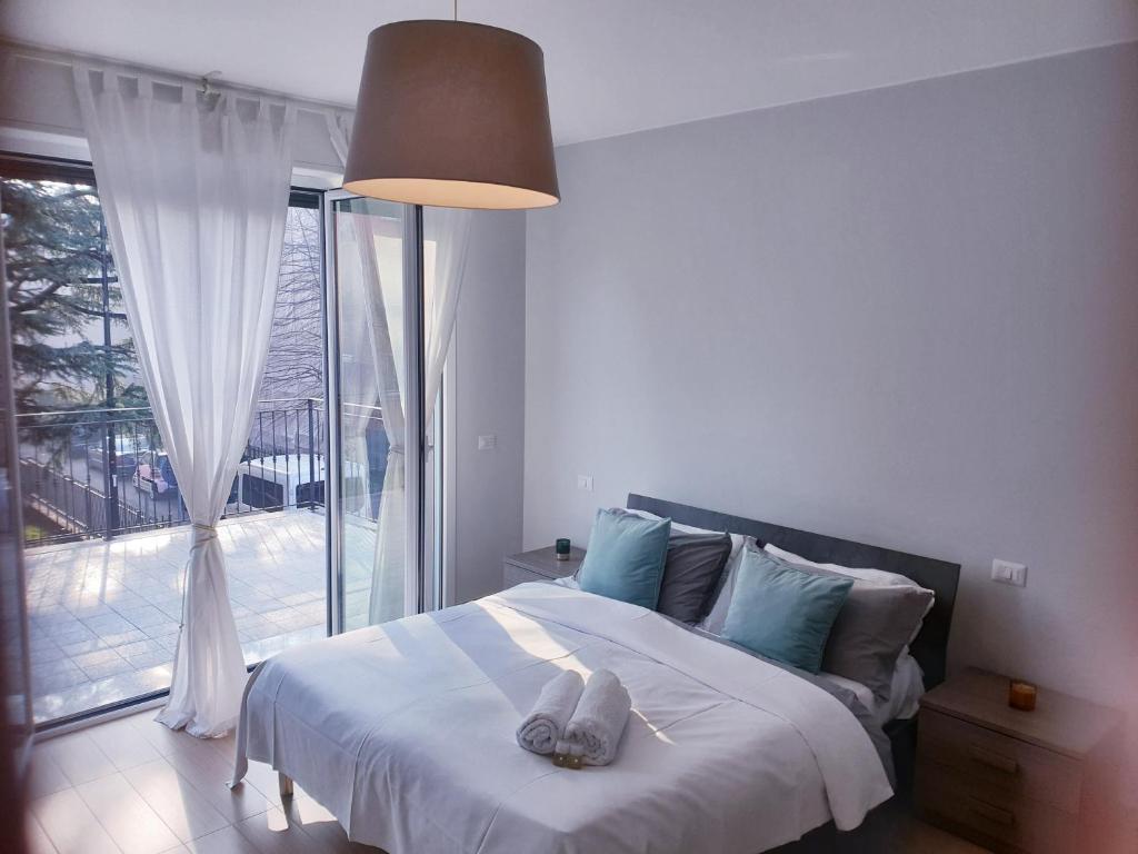 a bedroom with a bed and a large window at Michelangelo Apartments in Cormano