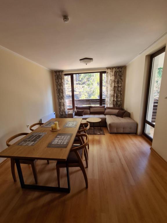 een woonkamer met een tafel en een bank bij Родопски Рай in Pamporovo