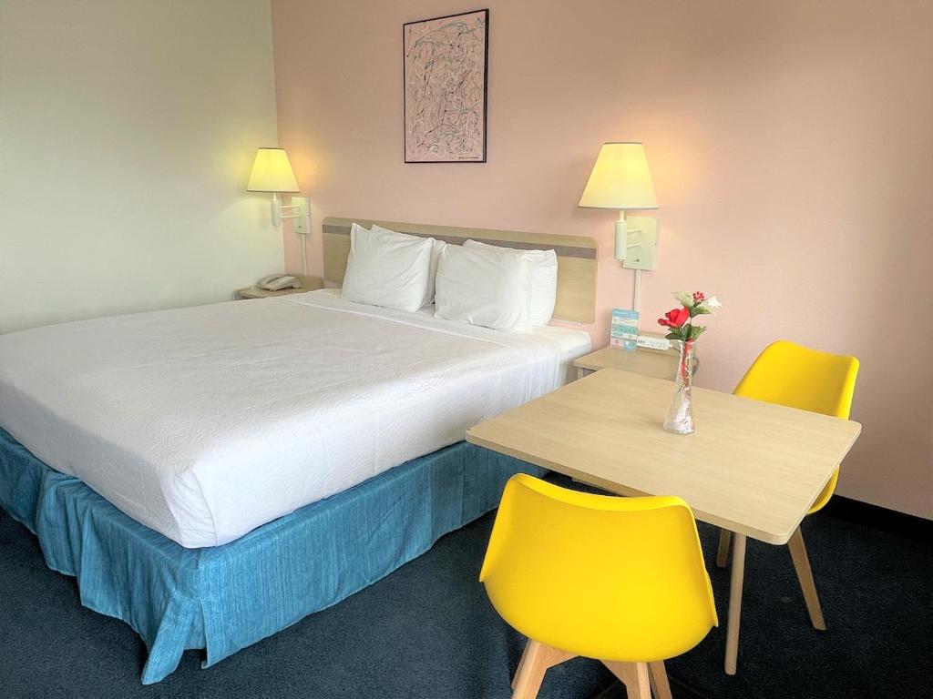 une chambre d'hôtel avec un lit, une table et des chaises dans l'établissement LuLu Silver City, à Silver City