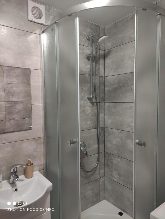 a shower with a glass door in a bathroom at Апартаменти центр біля озера in Ternopilʼ