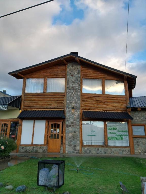 a wooden building with a mirror in front of it at LA CASA DE COCO ALOJAMIENTO TURÍSTICO in Dina Huapi