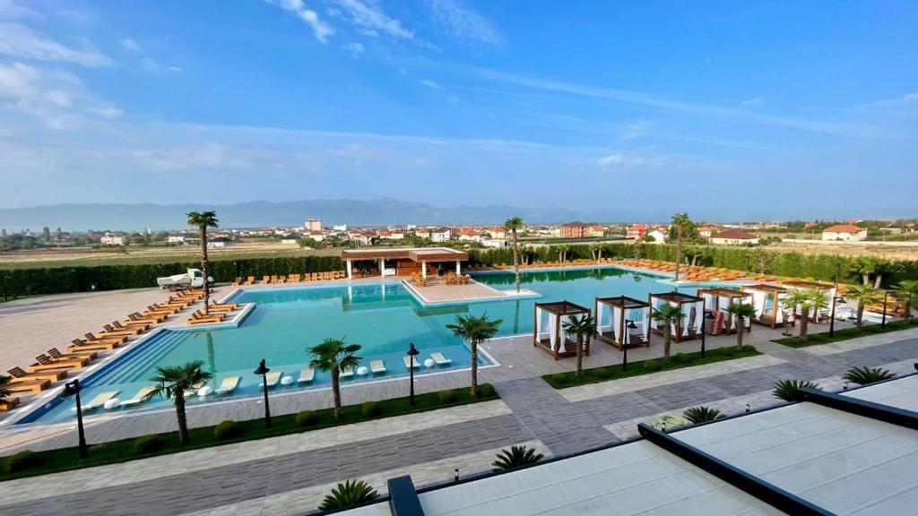 una vista sul tetto di una piscina con ombrelloni e palme di Deluxe Resort and SPA a Shkodër