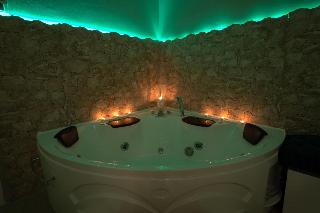 ein Badezimmer mit einer Badewanne mit Kerzen und Lichtern in der Unterkunft Le Dimore di Freya in Catania