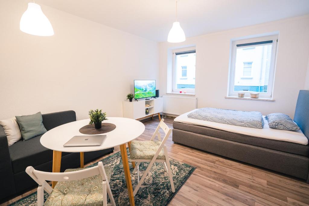 Sala de estar con cama y mesa en Ferienwohnung Maria - Gera Zentrum NEU renoviert en Gera
