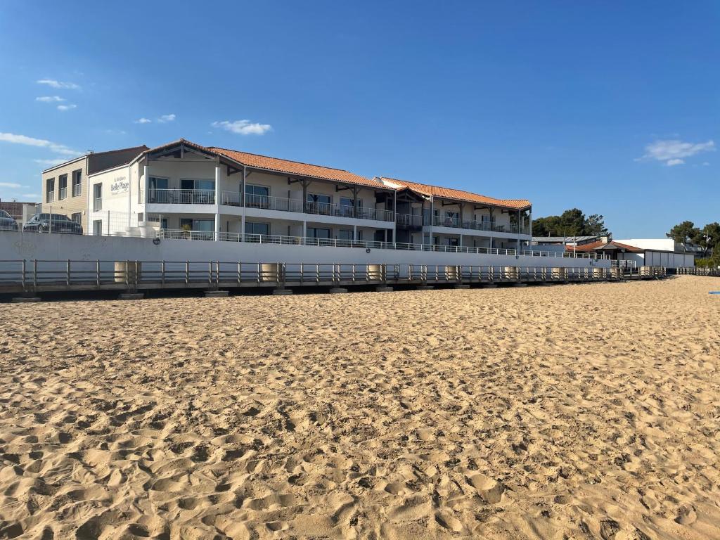 a building on the beach next to a sandy beach at Résidence Belle Plage in La Tranche-sur-Mer