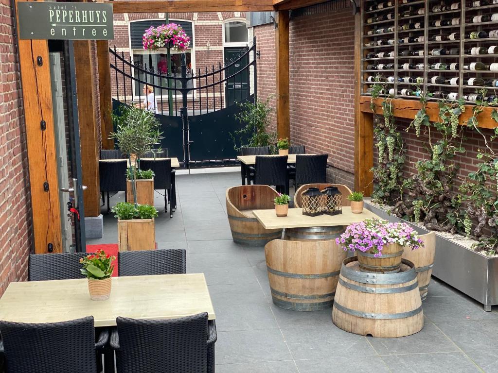 un patio al aire libre con mesas, sillas y flores en Hotel 't Peperhuys, en Kaatsheuvel