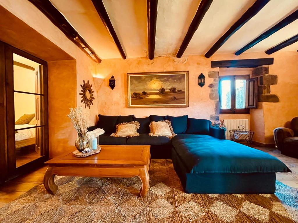 a living room with a blue couch and a table at Auténtica casa del SXVII en la Costa Brava in Cruïlles