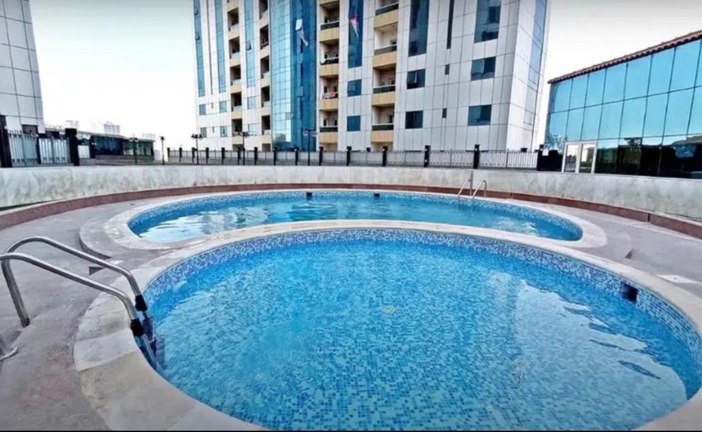 a large swimming pool in front of a building at Lemas 1001 in Ajman 
