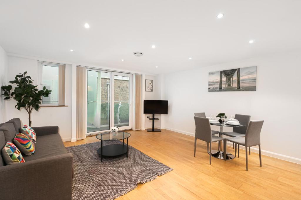 uma sala de estar com um sofá e uma mesa em Skyvillion - Station Road Apartment with Balcony & Parking em New Barnet