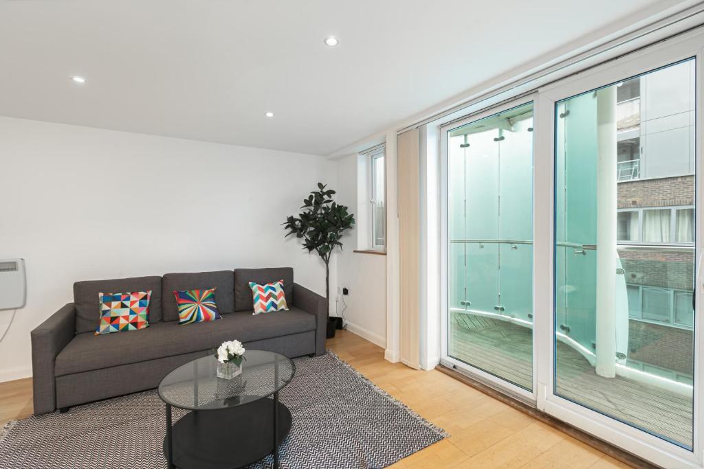 a living room with a couch and a large window at Beautiful 2Bed 2Bath Apartment 4Mins to Train Station with WiFi and Free Parking in New Barnet
