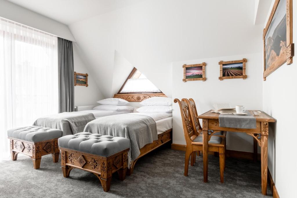 sypialnia z 2 łóżkami, stołem i biurkiem w obiekcie Aparthotel Białczański w mieście Białka Tatrzanska