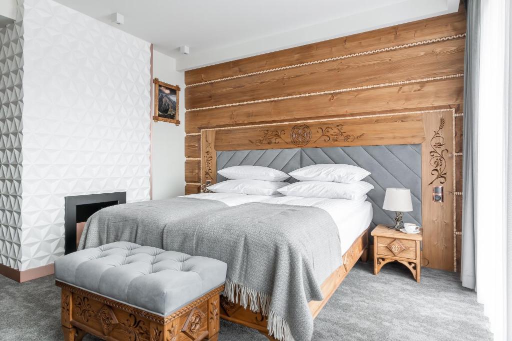 um quarto com uma cama grande com cabeceira de madeira em Aparthotel Białczański em Białka Tatrzanska