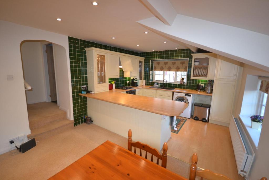 a kitchen with green tiled walls and a counter top at Eagle Cottage in Penrith