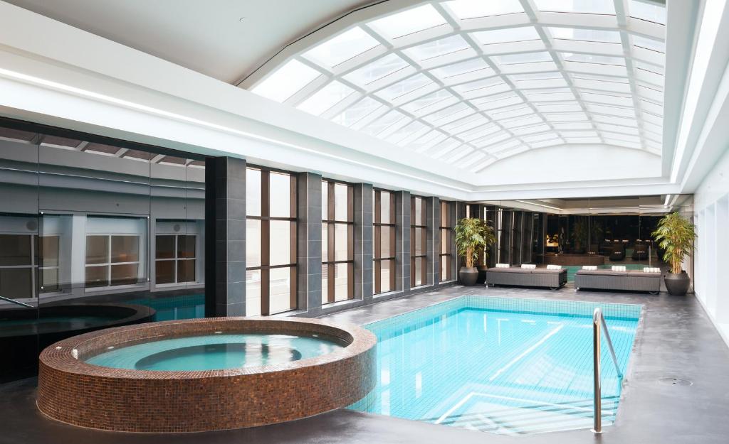 a pool in a building with a large ceiling at Stamford Plaza Melbourne in Melbourne