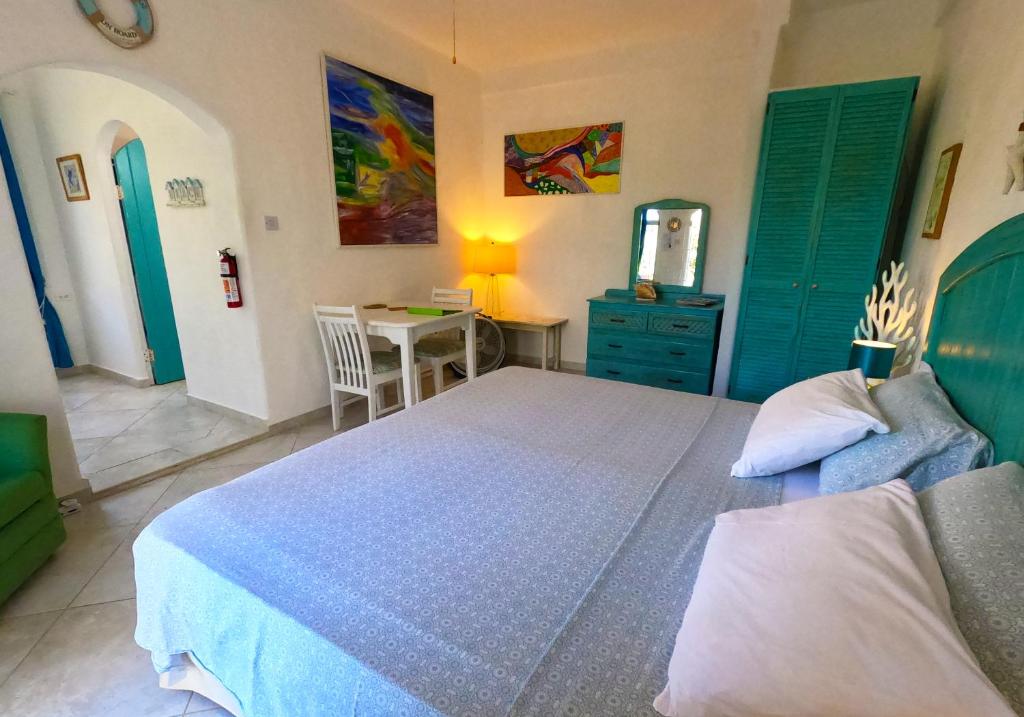 um quarto com uma cama e uma mesa com um espelho em Two Palms Apartment - in Sweet Jewel Apartments em Christ Church