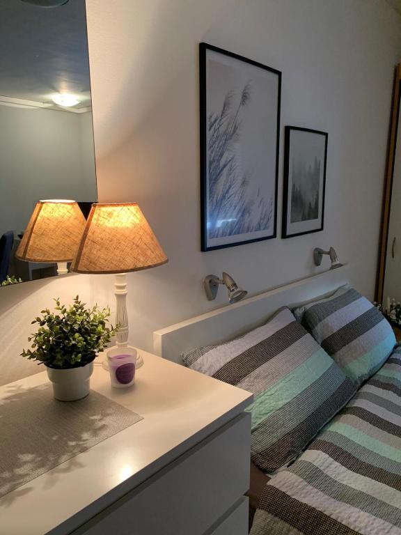 a bedroom with a bed and a table with a lamp at Šarmantni apartman Malecka 2 in Zagreb