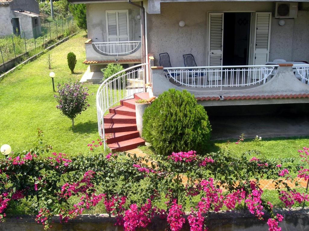 un jardin avec des fleurs roses en face d'une maison dans l'établissement Villa D'Agati, à San Giorgio