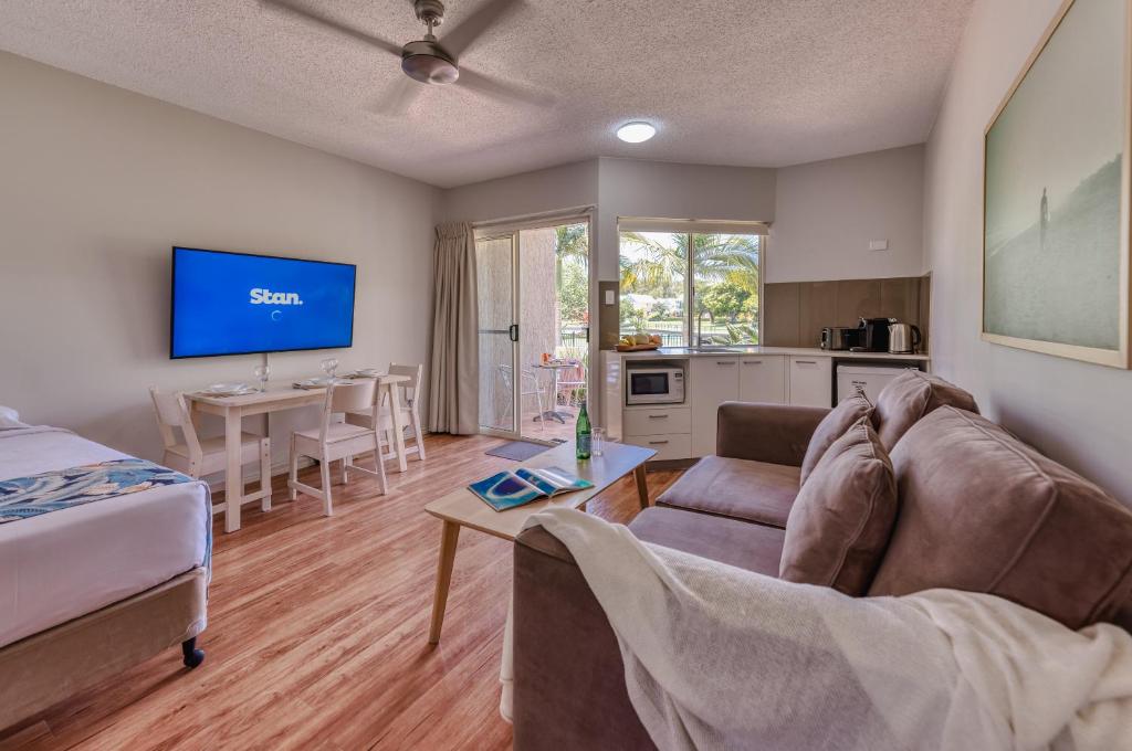 una sala de estar con un sofá y una mesa en Noosa Sun - On the Noosa River, en Noosaville