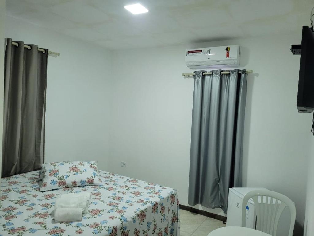 1 dormitorio pequeño con 1 cama y 1 silla en Pousada Beach Claudia, en Maragogi