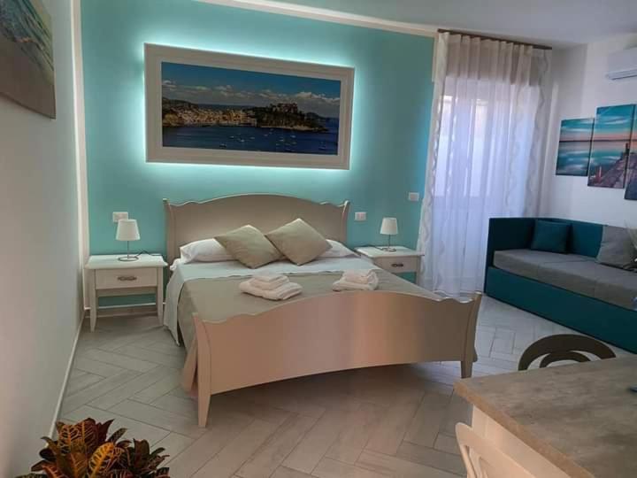 a bedroom with a large bed and a couch at B&B La Lingua in Procida