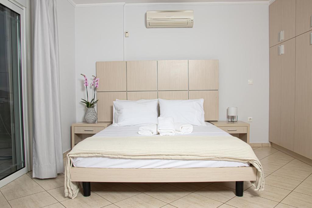 1 dormitorio con 1 cama con 2 toallas en SALTSEA BOUTIQUE VILLAS en Alikí