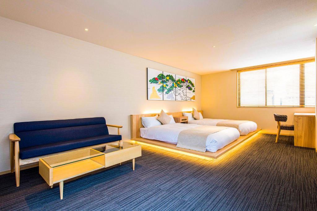 1 dormitorio con 1 cama y 1 sofá azul en Hotel ZIZI Kyoto Gion en Kyoto