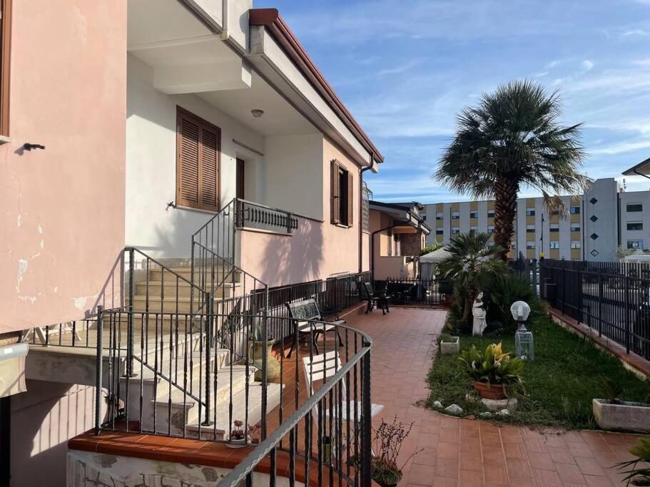 un bâtiment avec un escalier à côté d'un palmier dans l'établissement Villa Antonella, à Pozzilli