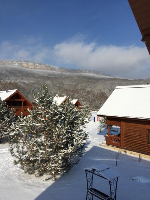 a ski lodge with snow on the ground and trees at Tourist Complex belaya Reka Dakhovskaya in Dakhovskaya