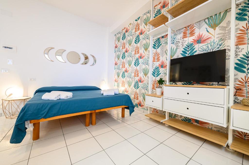 Schlafzimmer mit einem Bett und einem Flachbild-TV in der Unterkunft L'Aurora Apartments in Neapel