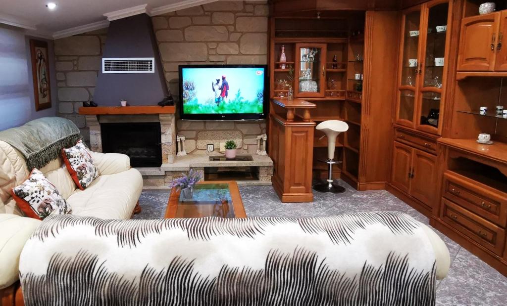 sala de estar con sofá y TV en Apartamento Camariñas, en Camariñas