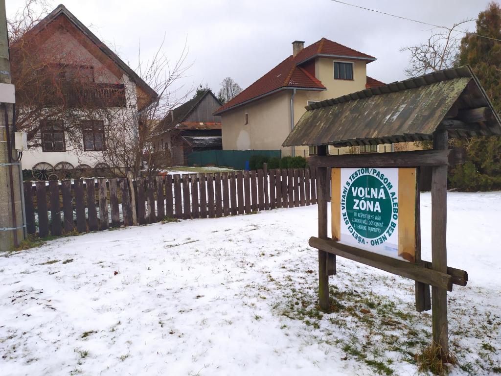 un cartel en la nieve frente a una casa en Gazdovsky dvor "U Tlaciarov", en Liptovský Trnovec