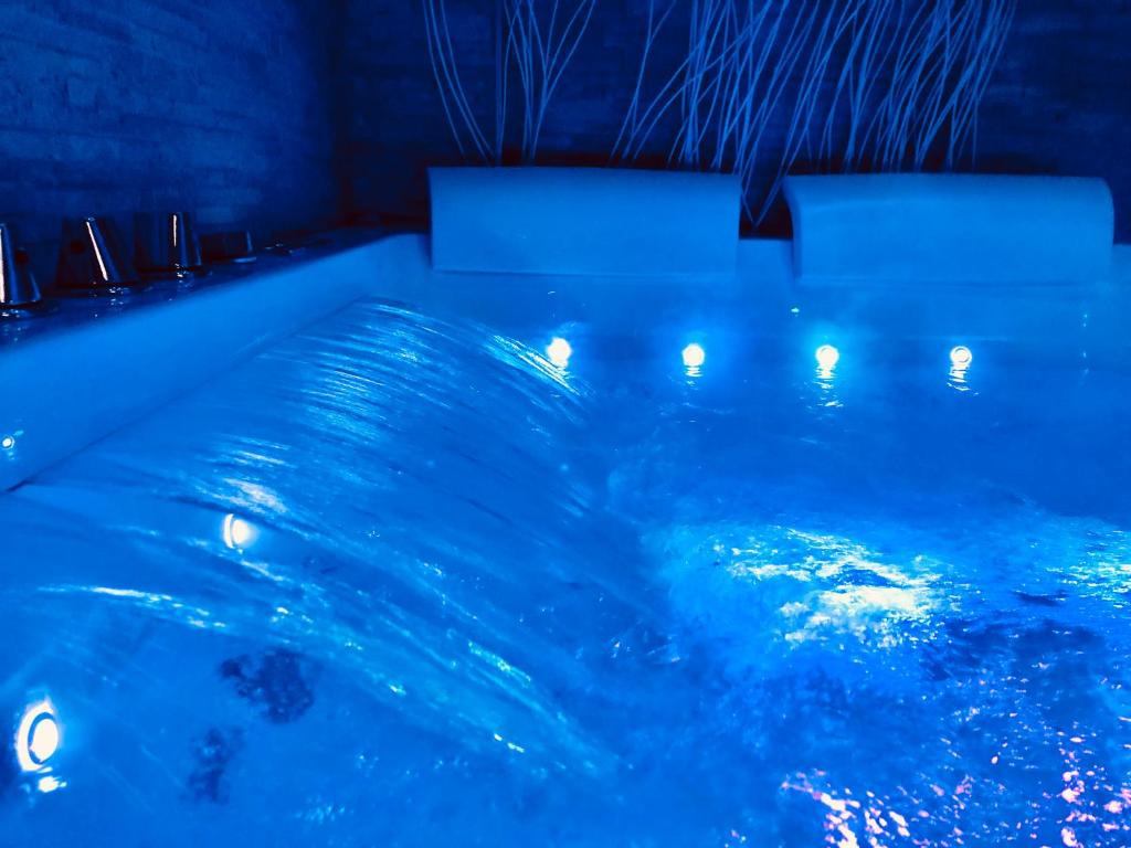 - une piscine d'eau bleue avec des lumières dans l'établissement YourHome - La Meta Perfetta Rooms&Spa, à Meta